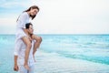 Young asian couple in love honeymoon at sea beach on blue sky. boyfriend piggy back ride to girlfriend . happy smiling wedding Royalty Free Stock Photo