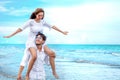 Young asian couple in love honeymoon at sea beach on blue sky. groom giving piggy back ride to bride . happy smiling wedding Royalty Free Stock Photo