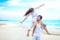 Young asian couple in love honeymoon at sea beach on blue sky. husband giving piggy back ride to wife . happy smiling wedding