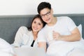 Young asian couple love man and woman watching movie in laptop on the bed in the morning. Happy moment concept Royalty Free Stock Photo