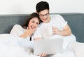 Young asian couple love man and woman watching movie in laptop on the bed in the morning. Happy moment concept Royalty Free Stock Photo