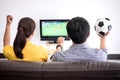 Young Asian couple love watching soccer match on tv and cheering Royalty Free Stock Photo