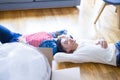 Young asian couple lying on the floor of new house arround cardboard boxes relaxing and smiling happy Royalty Free Stock Photo