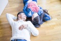 Young asian couple lying on the floor of new house arround cardboard boxes relaxing and smiling happy Royalty Free Stock Photo
