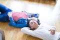 Young asian couple lying on the floor of new house arround cardboard boxes relaxing and smiling happy Royalty Free Stock Photo