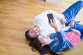 Young asian couple lying on the floor of new house smiling happy taking a selfie photo at new apartment Royalty Free Stock Photo
