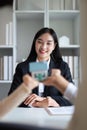 Young Asian couple making contract with house sale agency. man and his wife sitting signing the contract next to him Royalty Free Stock Photo