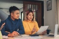 Young asian couple managing finances, reviewing their bank accounts using laptop computer and calculator at modern home. Royalty Free Stock Photo