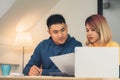 Young asian couple managing finances, reviewing their bank accounts using laptop computer and calculator at modern home. Woman and Royalty Free Stock Photo