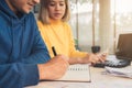 Young asian couple managing finances, reviewing their bank accounts using laptop computer and calculator at modern home. Royalty Free Stock Photo