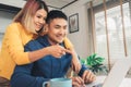 Young asian couple managing finances, reviewing their bank accounts using laptop computer and calculator at modern home. Royalty Free Stock Photo