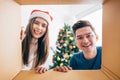 Young Asian couple opening a Christmas present together with a smile, views from inside of the box.