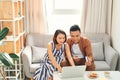 Young Asian couple paying bills by laptop with credit card at home Royalty Free Stock Photo