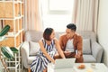 Young Asian couple paying bills by laptop and smartphone with credit card at home