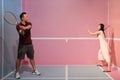 Young asian couple pretending playing tennis on a pastel pink and blue court. Royalty Free Stock Photo