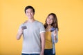 Young Asian couple showing credit cards isolated on yellow background Royalty Free Stock Photo