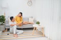 Young asian couple sitting on couch at home, using a tablet PC for Internet and social media Royalty Free Stock Photo