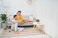 Young asian couple sitting on couch at home, using a tablet PC for Internet and social media