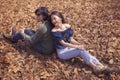 Young asian couple sitting on dry leaves ground