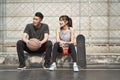 Young asian couple sitting on the side of a basketball court Royalty Free Stock Photo