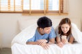 Young asian couple smile listen music with smart mobile phone on bed at bedroom with fun and enjoy Royalty Free Stock Photo