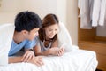 Young asian couple smile listen music with smart mobile phone on bed at bedroom with fun and enjoy Royalty Free Stock Photo