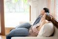 Young asian couple smile relax comfortable on sofa in the living room in holiday, family leisure and resting with happy