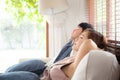 Young asian couple smile relax comfortable on sofa in the living room in holiday, family leisure and resting with happy