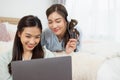 Young asian couple smiling happy using laptop at bedroom. Female friends are happily using credit cards for online shopping. Royalty Free Stock Photo