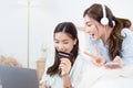 Young asian couple smiling happy using laptop at bedroom. Female friends are happily using credit cards for online shopping. Royalty Free Stock Photo