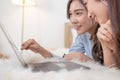 Young asian couple smiling happy using laptop at bedroom. Female friends are happily using credit cards for online shopping. Royalty Free Stock Photo