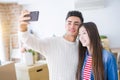 Young asian couple smiling taking a selfie photo with smartphone, moving to a new home together Royalty Free Stock Photo
