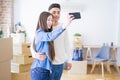 Young asian couple smiling taking a selfie photo with smartphone, moving to a new home together Royalty Free Stock Photo