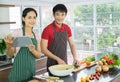 Young Asian couple. Standing smile cooking in the kitchen. prepare salad for food together happily. Royalty Free Stock Photo