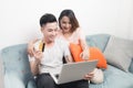 Young asian couple surfing on internet and shopping with laptop. Modern white apartment in background Royalty Free Stock Photo