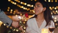 Young asian couple surprise moment with rose flower at romantic dinner in rooftop restaurant at city night with sweet moment Royalty Free Stock Photo