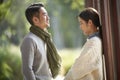 Young asian couple talking chatting outdoors in city park Royalty Free Stock Photo
