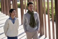 Young asian couple walking outdoors in city park Royalty Free Stock Photo