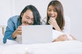 Young Asian couple watching movie with laptop in the bed.