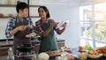 Young Asian couples are happy to cook together, two families are helping each other prepare to cook in the kitchen Royalty Free Stock Photo