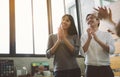 Young Asian creative business people clapping hands at the meeting