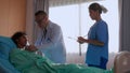 Young asian doctor man checkup and examining patient with stethoscope for listening heartbeat on bed while nurse writing document. Royalty Free Stock Photo