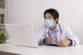 Asian Doctor and Stethoscope Wear Face Mask Write Experimental Results Report and Using Laptop Computer Royalty Free Stock Photo