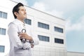 Young asian doctor man with white lab coat holding stethoscope w Royalty Free Stock Photo