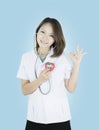 Young Asian doctor stand holding a red heart in her hand with smiley face.