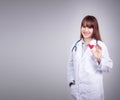 Young Asian doctor stand holding a red heart in her hand Royalty Free Stock Photo