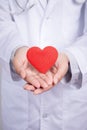 Young Asian doctor stand holding a red heart with two hands.