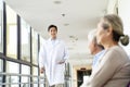 Young asian doctor meeting walking in hospital hallway Royalty Free Stock Photo