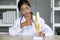 Young asian doctor in white gown and stethoscope pointing at anterior cruciate ligament on deluxe functional knee joint model