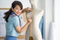 Young asian dressmaker use tape measure, measuring chest size of the mannequin. Fashion designer room Royalty Free Stock Photo